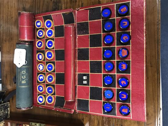 A 19th century Jaques Patent portable B.C.D. backgammon, chess and draughts board set, the gilt tooled red morocco cylinder holder
